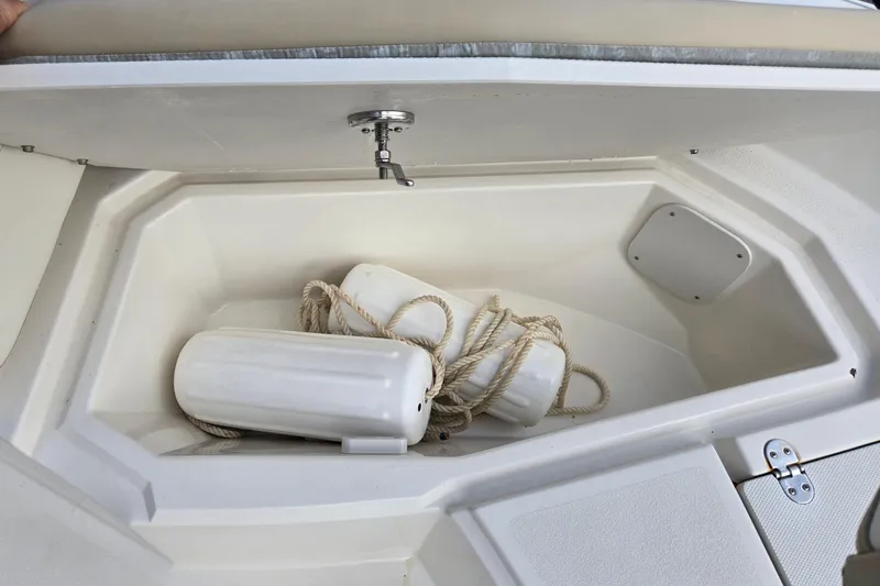 Slide: The Image of Open storage compartment on 2017 Stingray 206cc boat with white fenders and rope. - 21
