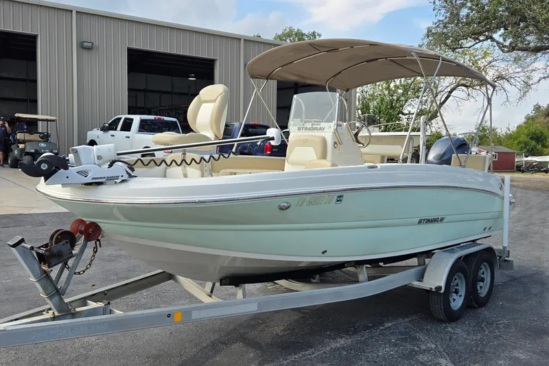 Slide: The Image of 2017 Stingray 206cc boat on trailer, parked outside a warehouse. - 7