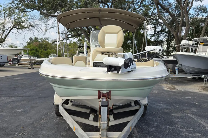 Slide: The Image of 2017 Stingray 206cc boat on trailer, parked outdoors with trees in background. - 8