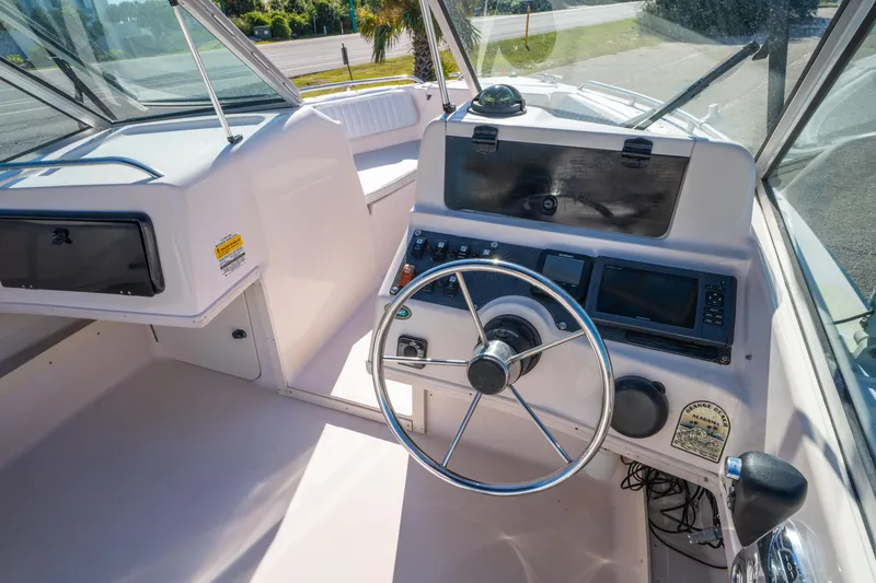 Slide: The Image of 1999 Grady-White Tournament 192 boat cockpit with steering wheel and control panel. - 11