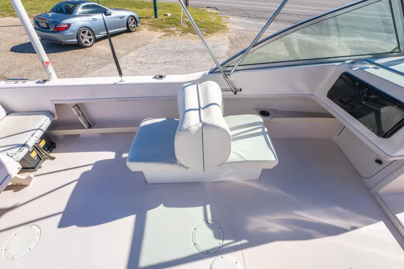 Slide: The Image of 1999 Grady-White Tournament 192 boat interior with seating, parked car in background. - 17