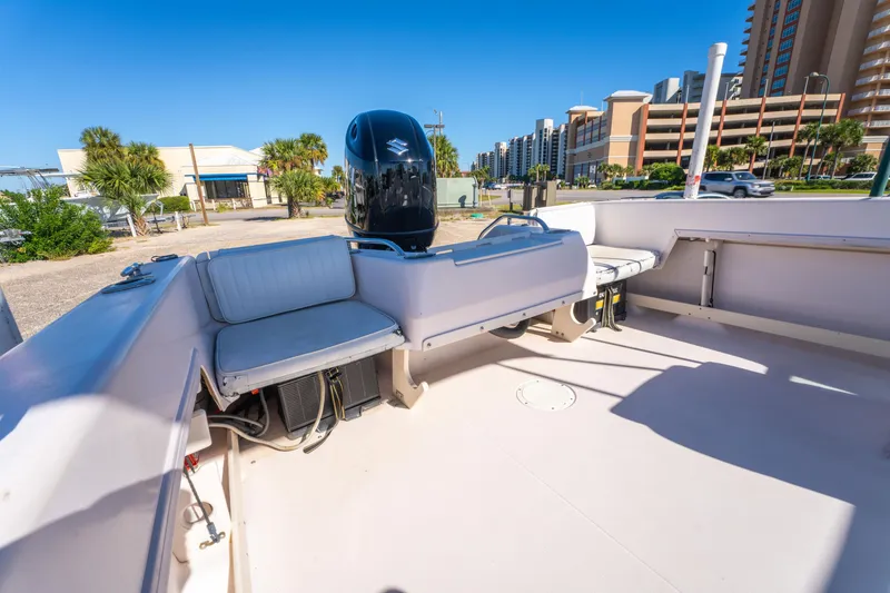 Slide: The Image of 1999 Grady-White Tournament 192 boat interior with seating and motor, sunny day, urban backdrop. - 18