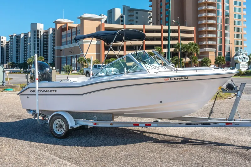 Slide: The Image of 1999 Grady-White Tournament 192 boat on trailer, urban background with buildings. - 2