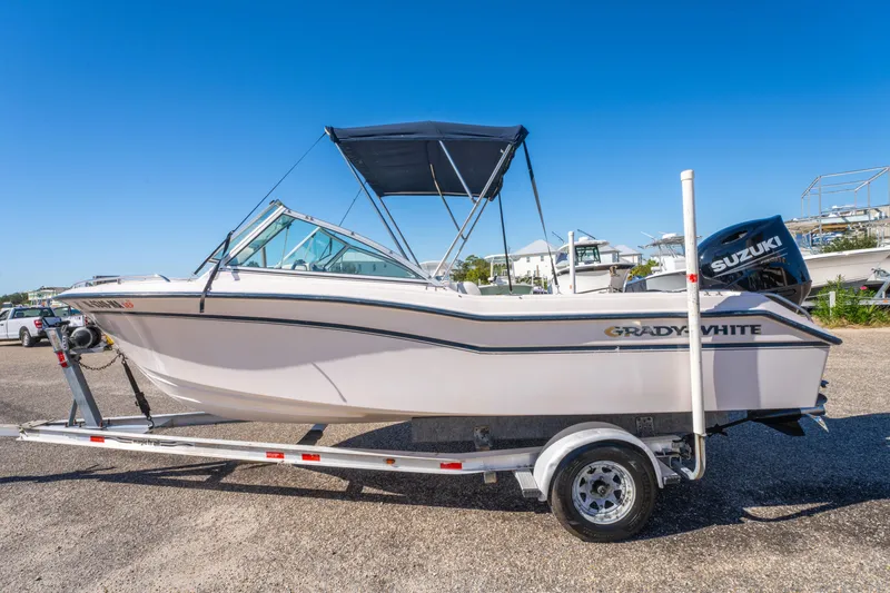 Slide: The Image of 1999 Grady-White Tournament 192 boat on trailer, clear sky background. - 4