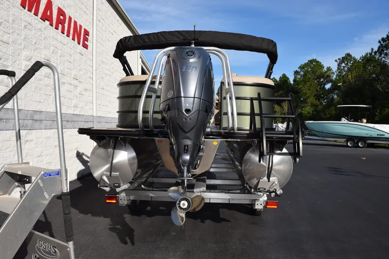 Slide: The Image of 2026 Bentley Pontoons Legacy 223 Navigator with outboard motor, parked at a marine dealership. - 5
