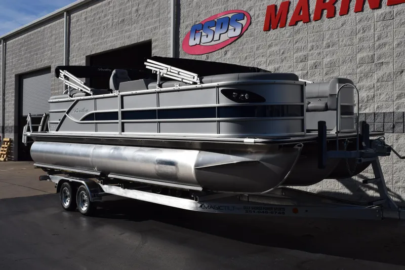 Slide: The Image of 2026 Bentley Pontoons Legacy 243 Navigator on trailer outside marine dealership. - 2