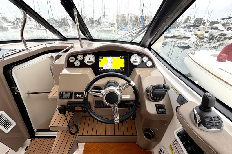 Slide: The Image of 2017 Regal 35 Sport Coupe helm with navigation display and controls in marina setting. - 16