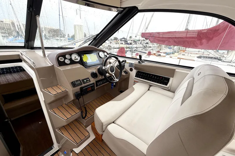Slide: The Image of Interior of 2017 Regal 35 Sport Coupe boat, featuring helm with navigation controls and plush seating. - 19
