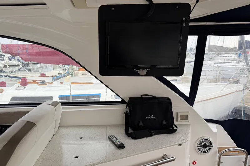 Slide: The Image of Interior of 2017 Regal 35 Sport Coupe with TV, remote, and branded bag. - 25