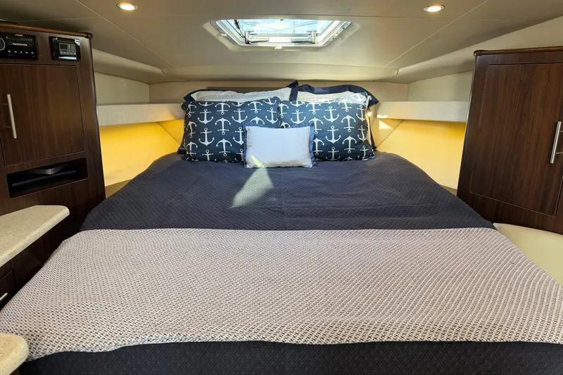 Slide: The Image of Luxurious cabin interior of 2017 Regal 35 Sport Coupe with nautical-themed bedding. - 26