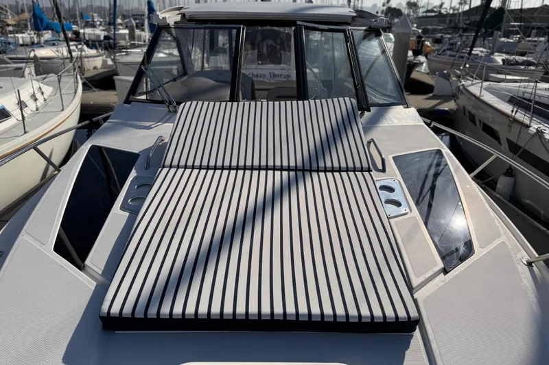 Slide: The Image of 2017 Regal 35 Sport Coupe yacht with striped sun pad, docked in marina. - 36