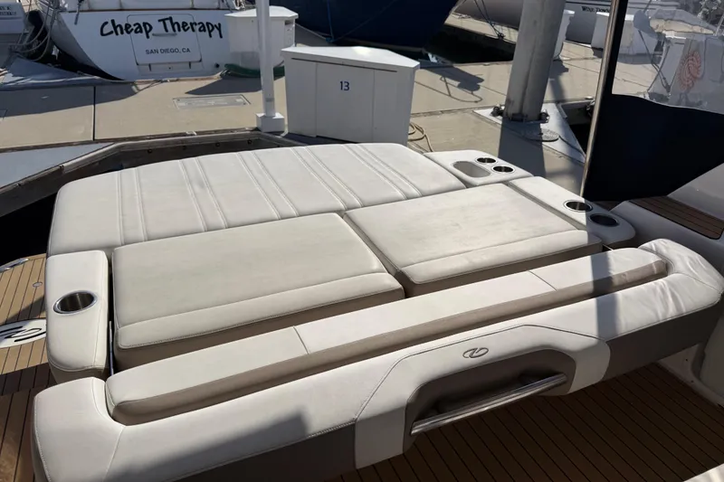 Slide: The Image of 2017 Regal 35 Sport Coupe boat with cushioned seating and cup holders at a marina. - 38