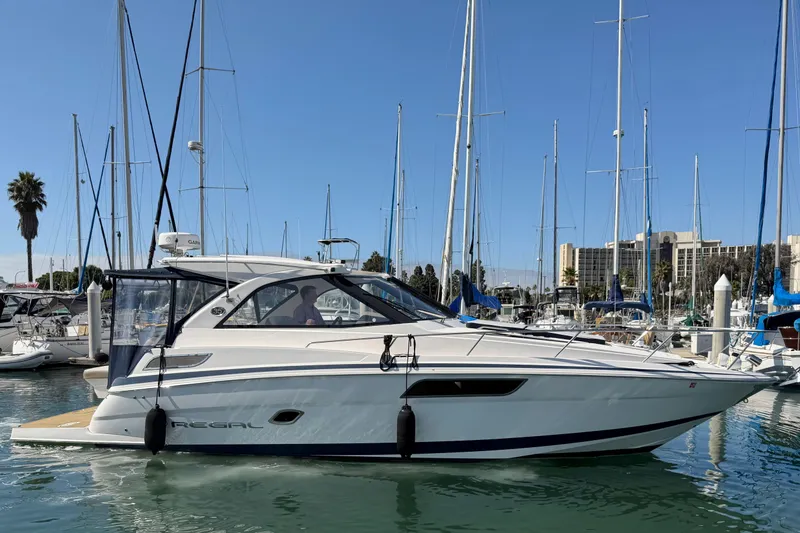 Slide: The Image of 2017 Regal 35 Sport Coupe yacht docked in a marina under clear blue skies. - 46