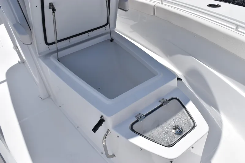 Slide: The Image of 2026 Sea Hunt Gamefish 27 Coffin Box, open storage compartment on a sleek white boat. - 21
