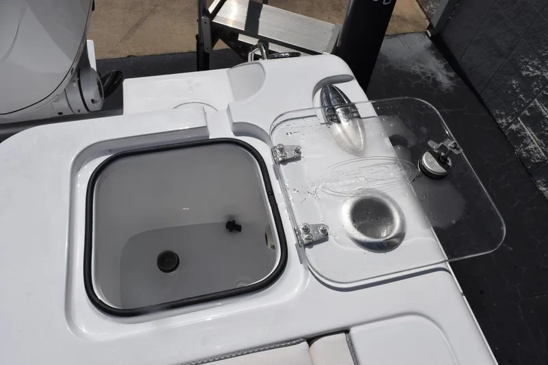Slide: The Image of 2026 Sea Hunt Gamefish 27 Coffin Box boat detail with open storage compartment and clear lid. - 22