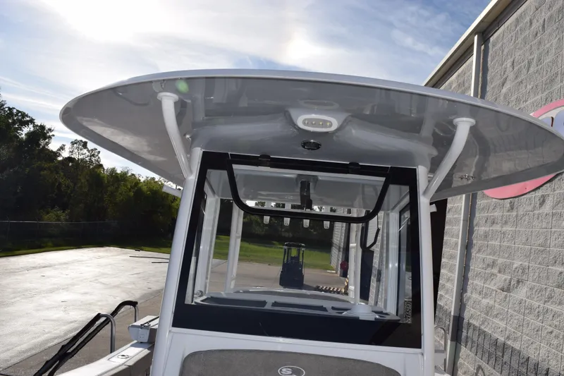 Slide: The Image of 2026 Sea Hunt Ultra 285 SE boat with T-top, parked outdoors near a building. - 15