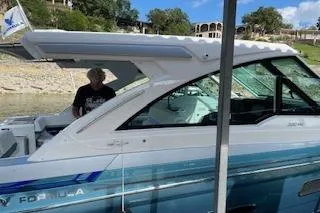 Slide: The Image of 2021 Formula 380 Super Sport Crossover I/O docked by a lakeside. - 2