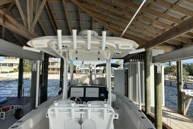 Slide: The Image of 2015 Sea Hunt Gamefish 25 boat docked under a wooden shelter with Garmin electronics. - 11