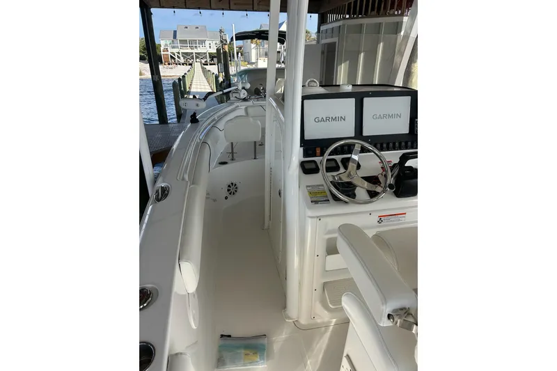 Slide: The Image of 2015 Sea Hunt Gamefish 25 boat interior with Garmin navigation displays and steering wheel. - 13
