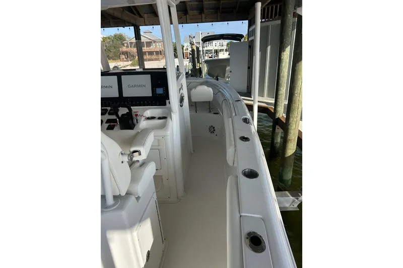 Slide: The Image of 2015 Sea Hunt Gamefish 25 boat interior with Garmin displays, docked under a shelter. - 14
