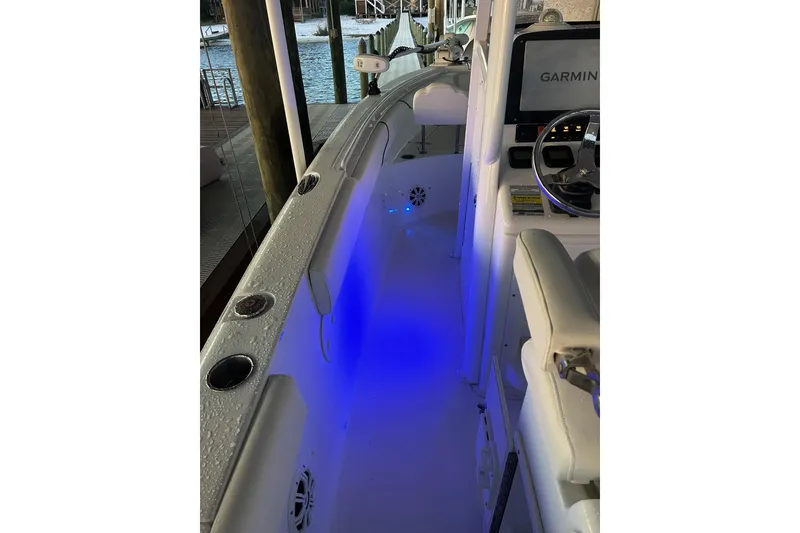 Slide: The Image of 2015 Sea Hunt Gamefish 25 boat interior with blue LED lighting and Garmin navigation system. - 15