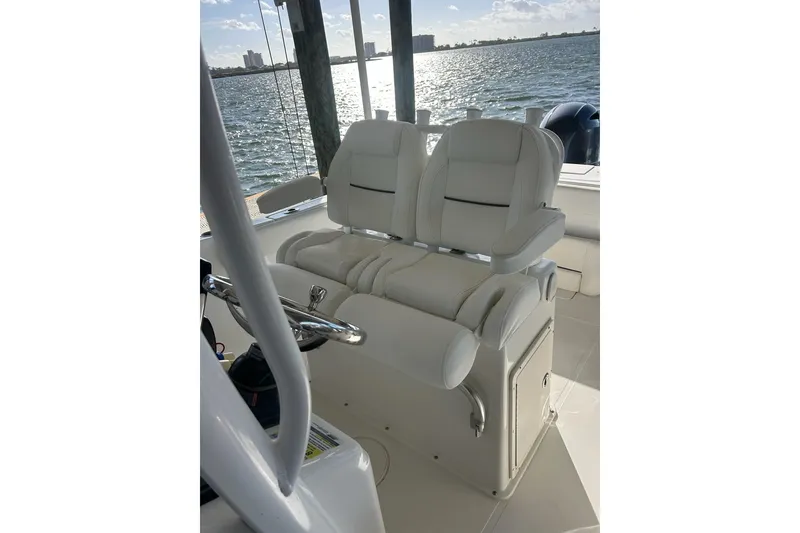 Slide: The Image of 2015 Sea Hunt Gamefish 25 boat interior with white seating and ocean view. - 17