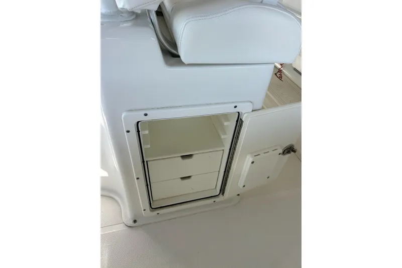 Slide: The Image of 2015 Sea Hunt Gamefish 25 boat storage compartment with drawers and white seating. - 18