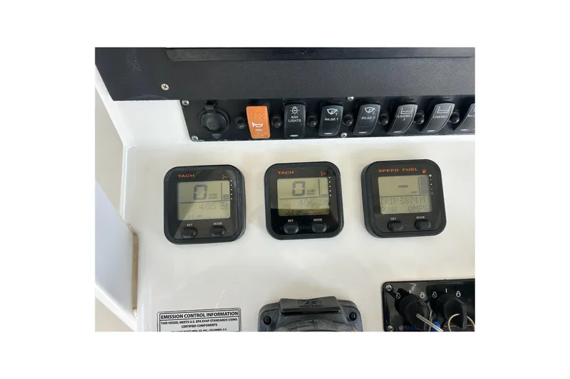Slide: The Image of Control panel of a 2015 Sea Hunt Gamefish 25 boat with digital displays and switches. - 24