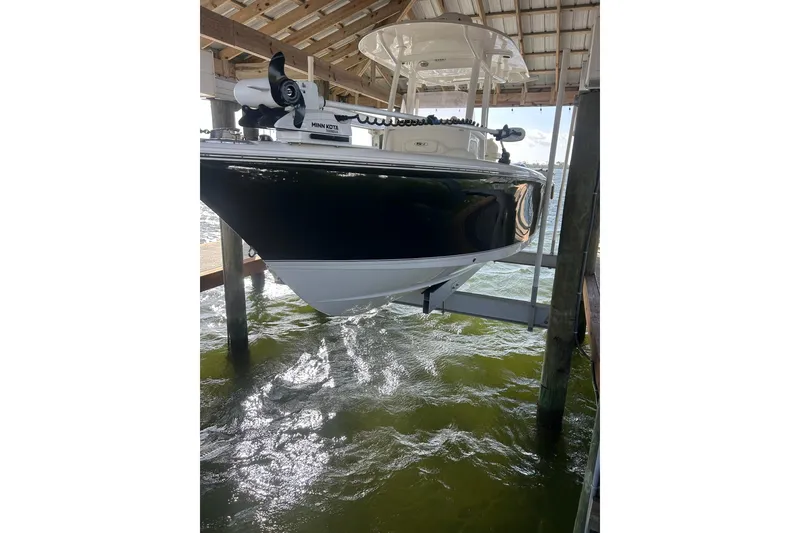 Slide: The Image of 2015 Sea Hunt Gamefish 25 boat on lift, under covered dock, with Minn Kota motor. - 3