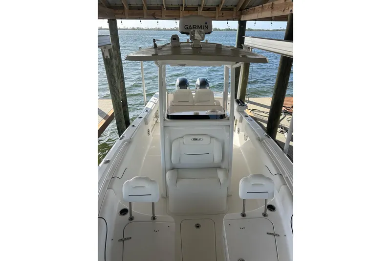 Slide: The Image of 2015 Sea Hunt Gamefish 25 boat docked, featuring spacious deck and Garmin equipment. - 31