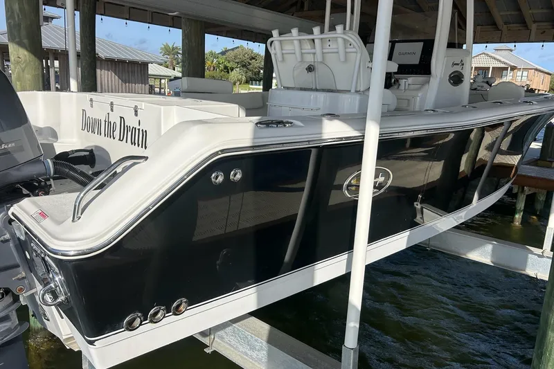 Slide: The Image of 2015 Sea Hunt Gamefish 25 boat docked, featuring sleek black and white design. - 4