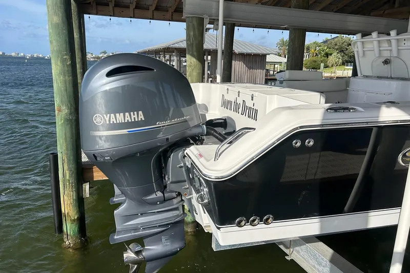 Slide: The Image of 2015 Sea Hunt Gamefish 25 with Yamaha outboard motor docked by the water. - 5