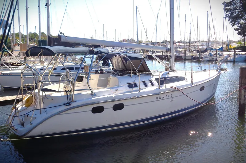 The Image of 2001 Hunter 380 sailboat docked in a marina, surrounded by other boats. - 0
