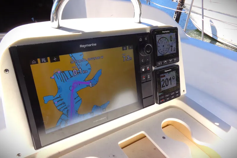 Slide: The Image of Cozy interior of 2001 Hunter 380 sailboat with blue seating, wood finish, and a small TV. - 15