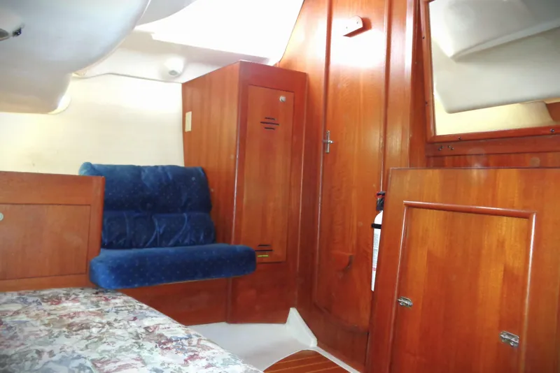 Slide: The Image of Interior of 2001 Hunter 380 sailboat with control panel and blue cushioned seating. - 8