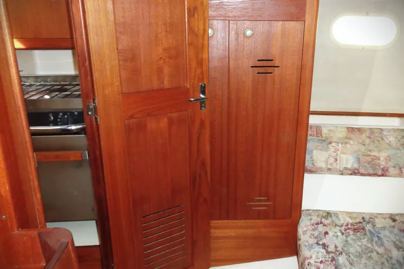 Slide: The Image of Cozy interior of 2001 Hunter 380 sailboat with navigation panel and cushioned seating. - 9