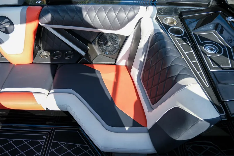 Slide: The Image of 2021 Tigé 21ZX boat interior with black, white, and orange seating, cup holders, and speaker. - 19