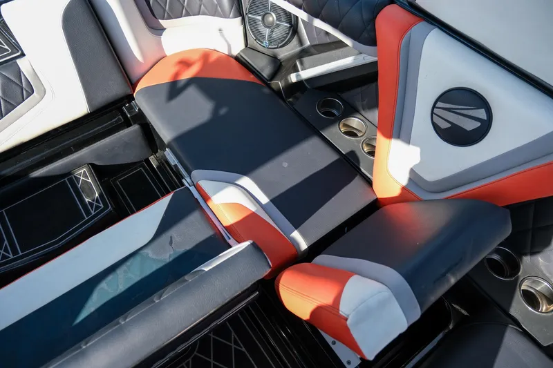 Slide: The Image of 2021 Tigé 21ZX boat interior with orange and black seating and cup holders. - 22