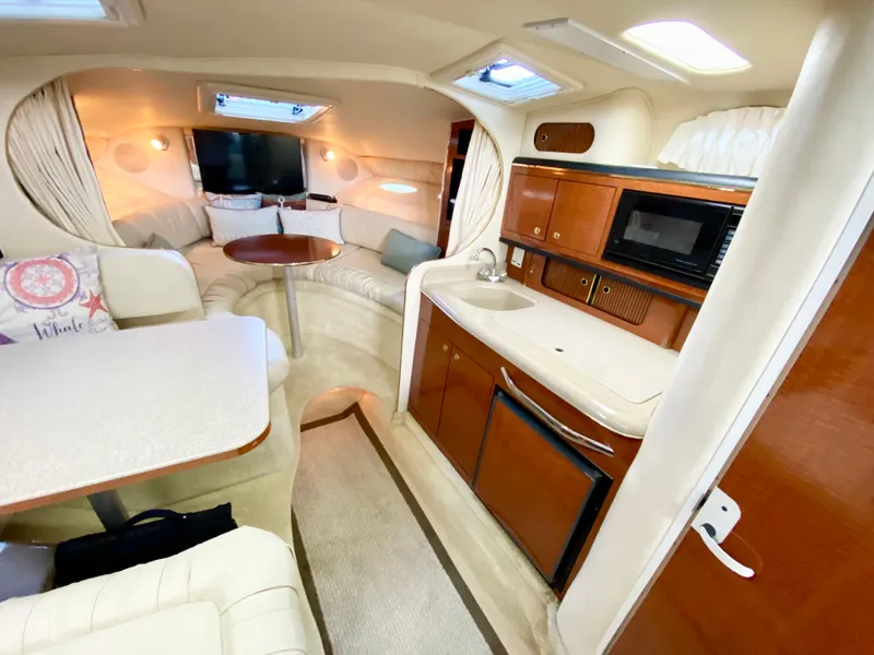 Slide: The Image of Interior of 2001 Sea Ray 290 Sundancer yacht with kitchenette and seating area. - 10