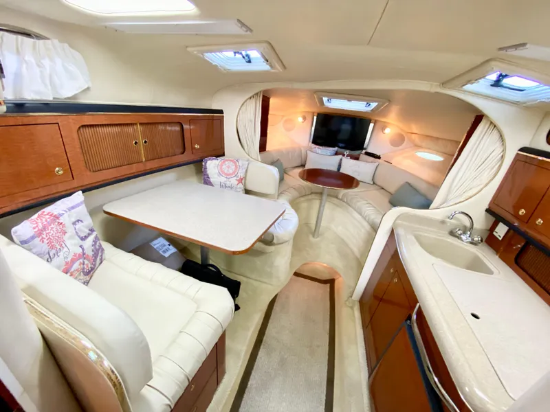 Slide: The Image of Luxurious interior of 2001 Sea Ray 290 Sundancer yacht with seating, table, and kitchenette. - 11