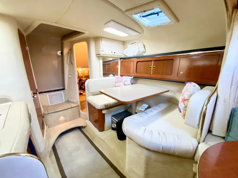 Slide: The Image of Interior of 2001 Sea Ray 290 Sundancer yacht with cozy seating and dining area. - 12
