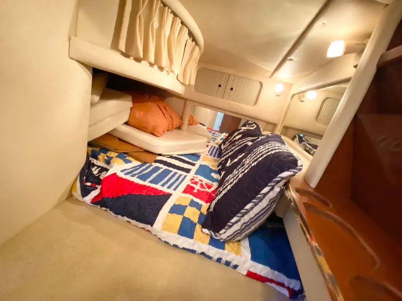 Slide: The Image of Interior cabin of 2001 Sea Ray 290 Sundancer with colorful bedding and cozy lighting. - 15