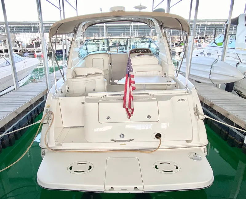 Slide: The Image of 2001 Sea Ray 290 Sundancer boat docked with American flag, rear view. - 3