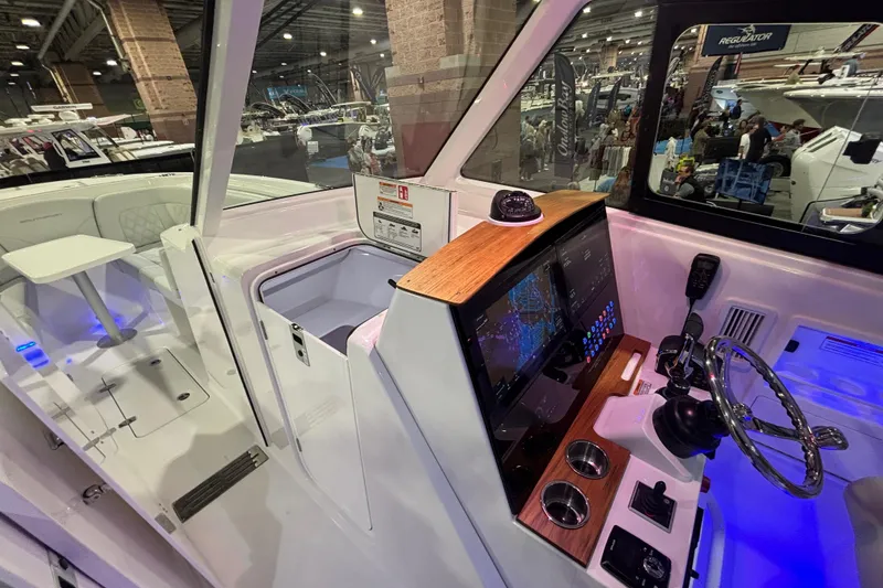 Slide: The Image of Interior view of 2026 Southport 33 DC boat at a boat show, showcasing helm and seating area. - 15