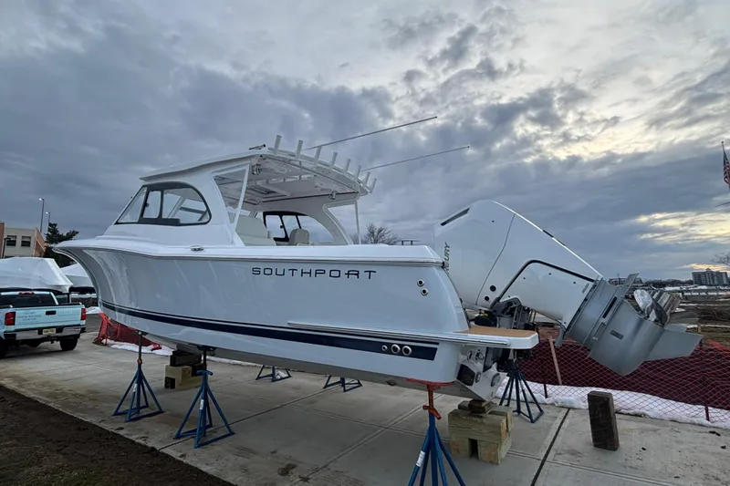Slide: The Image of 2026 Southport 33 DC boat on stands, cloudy sky background. - 27