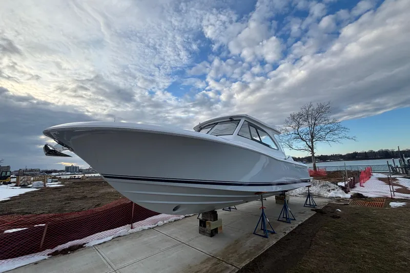 Slide: The Image of 2026 Southport 33 DC boat on stands, cloudy sky, waterfront view. - 29