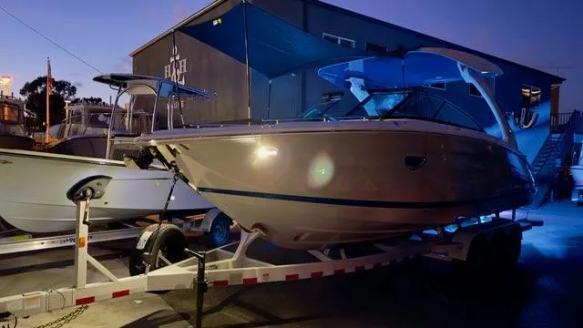 Slide: The Image of 2025 Regal LS9 Surf boat on trailer at dusk, illuminated by soft lighting. - 128