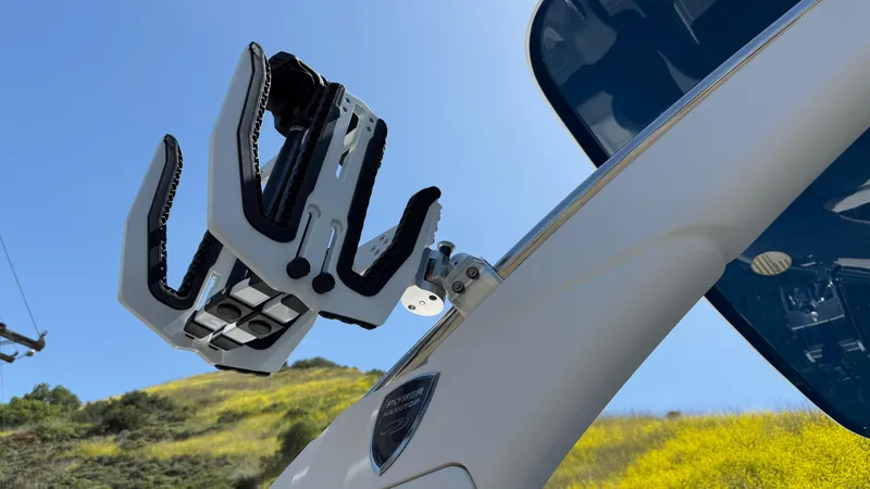 Slide: The Image of 2025 Regal LS9 Surf boat with advanced wakeboard rack against a clear blue sky. - 28