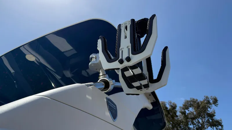 Slide: The Image of 2025 Regal LS9 Surf boat with wakeboard rack against clear blue sky. - 29