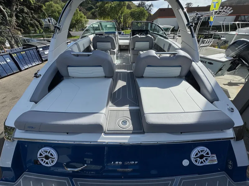 Slide: The Image of 2025 Regal LS9 Surf boat with spacious seating and modern design, docked outdoors. - 34
